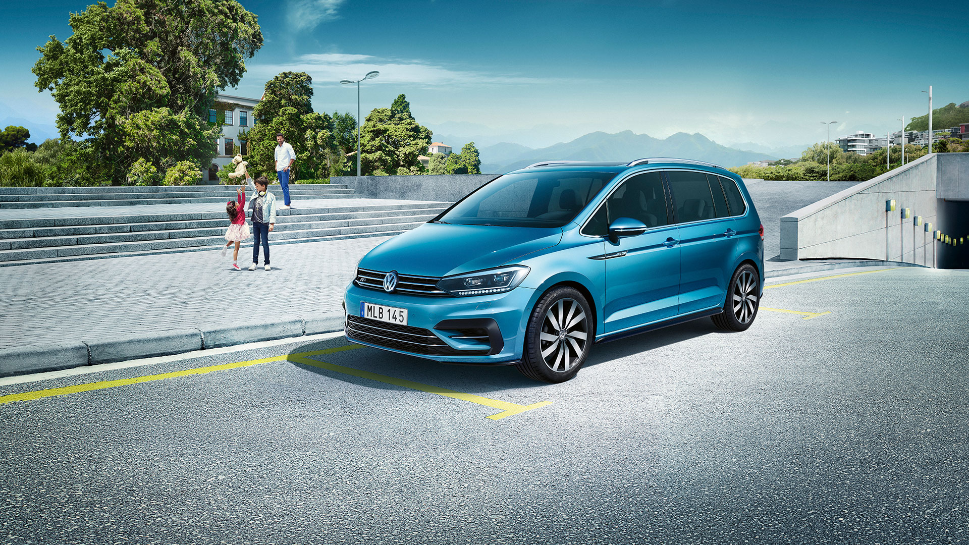 Volkswagen Touran. Bla Bil Med Familj I Bakgrunden