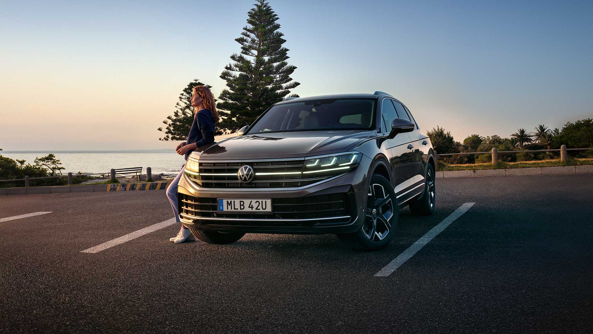 Volkswagen Touareg. Kvinna Står Lutad Mot Bilen.